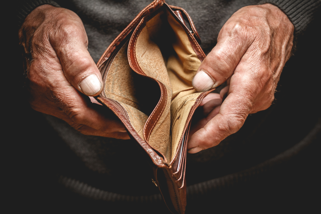 Elderly man holding an empty wallet open